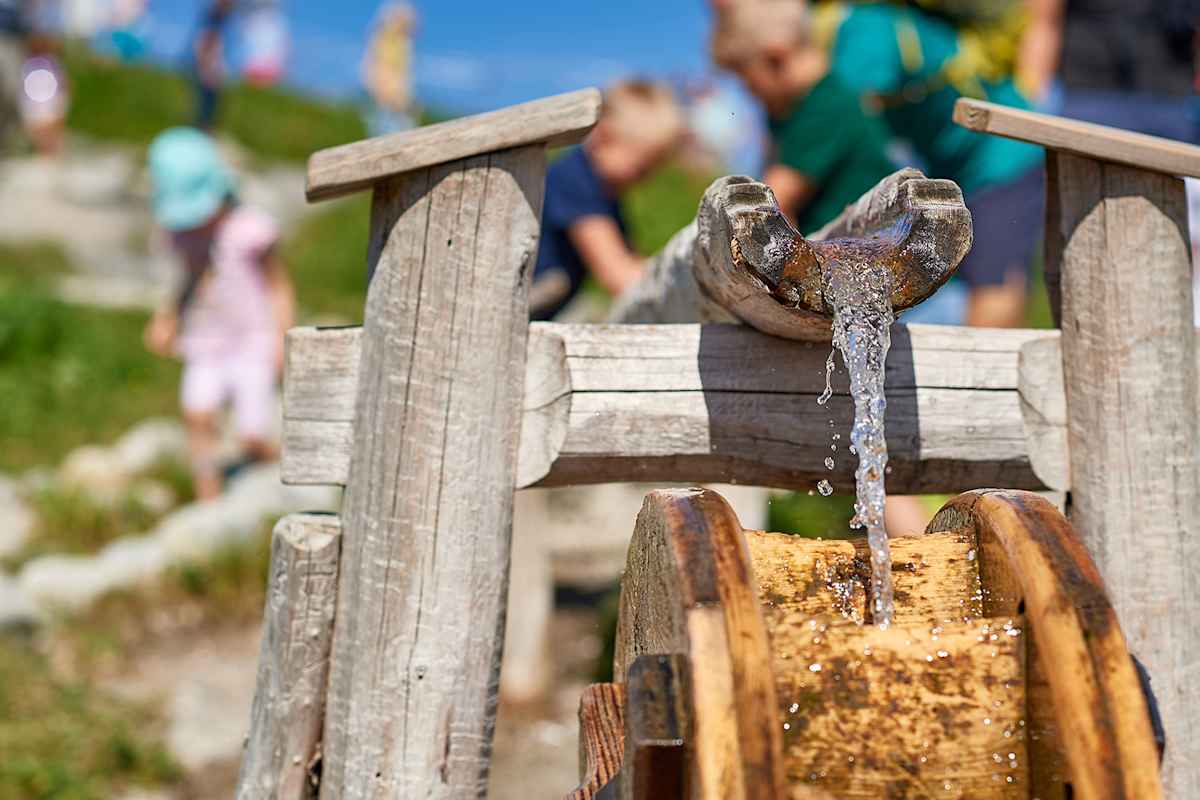 Spielerische Elemente wie das Wasserrad machen den Burmiweg zum Erlebnis für Groß und Klein.