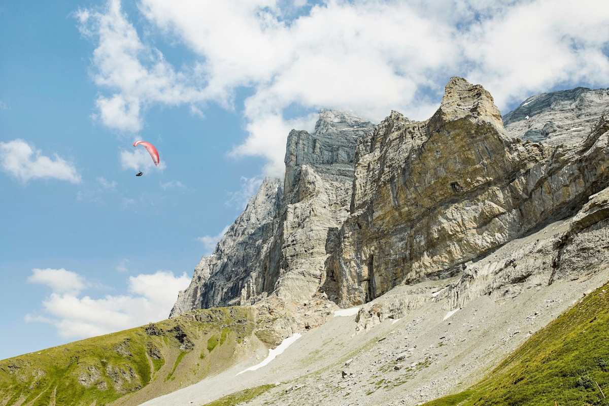 Ein Sportler mit einem Paragleiter in der Luft.