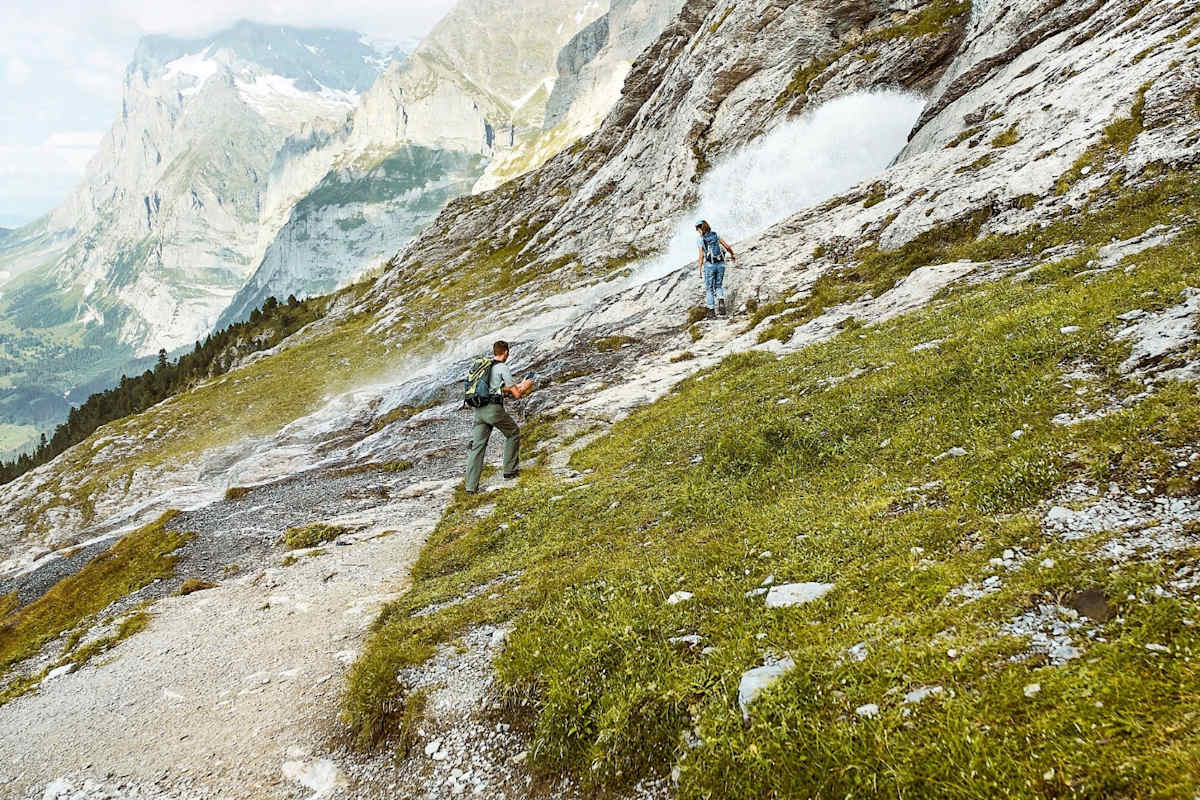 Bergsteiger vor einem Wasserfall.
