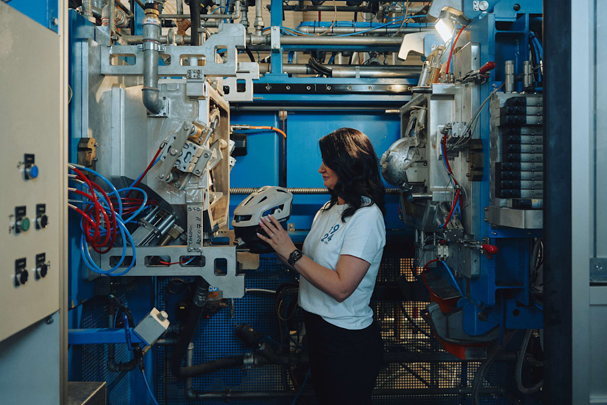 Eine Dame in der Fabrik von Abus in Italien stellt einen Helm her