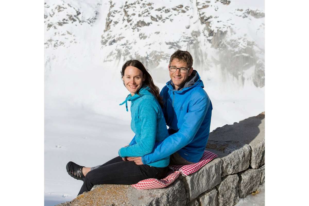Die Hüttenwirte posieren auf einer Mauer.