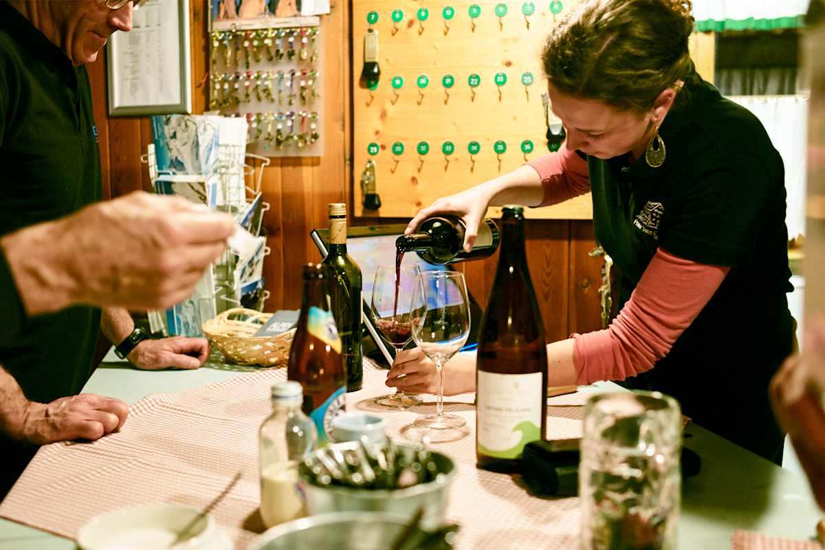 Die Wirtin schenkt einen guten Tropfen Wein ein.