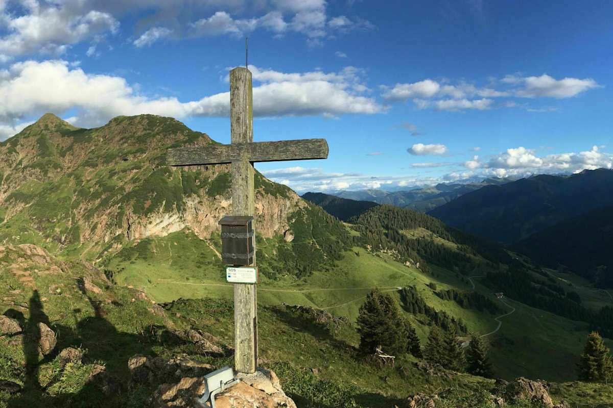 Gipfelkreuz vor Bergpanorama