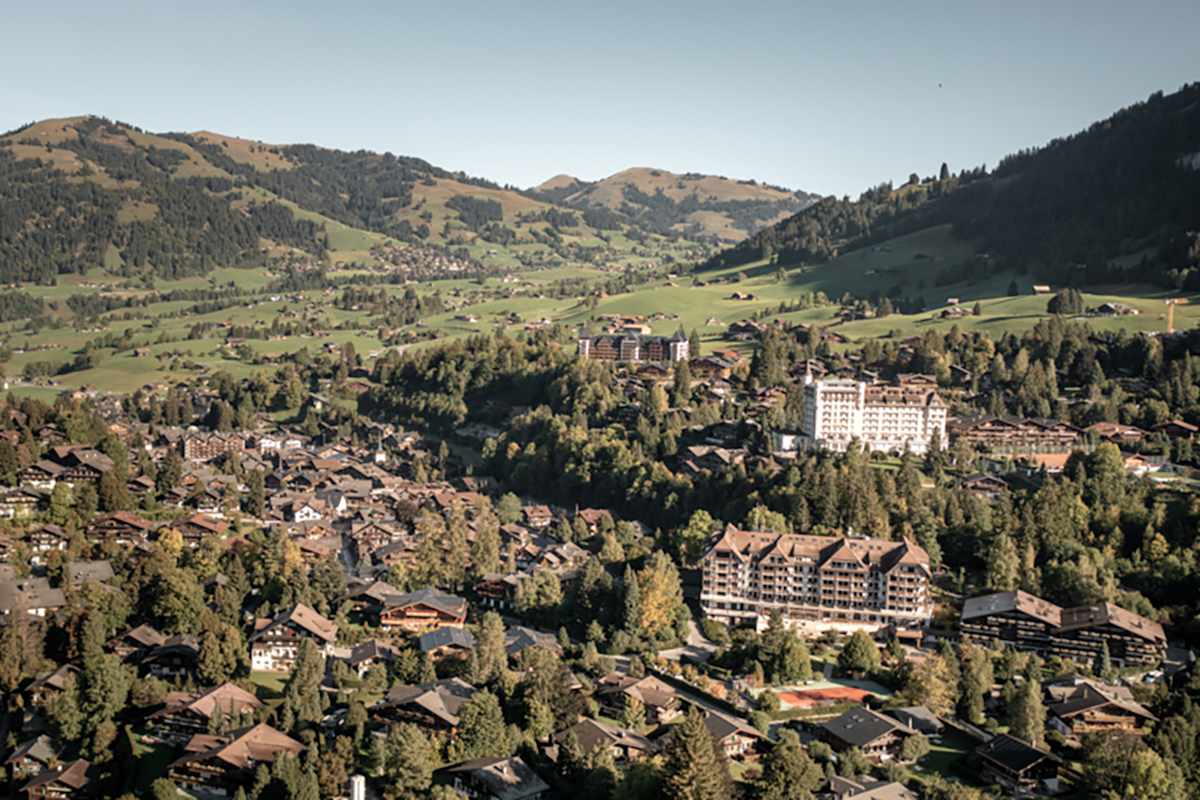 Luftaufnahme von Gstaad mit Blick auf die umliegende Berglandschaft.