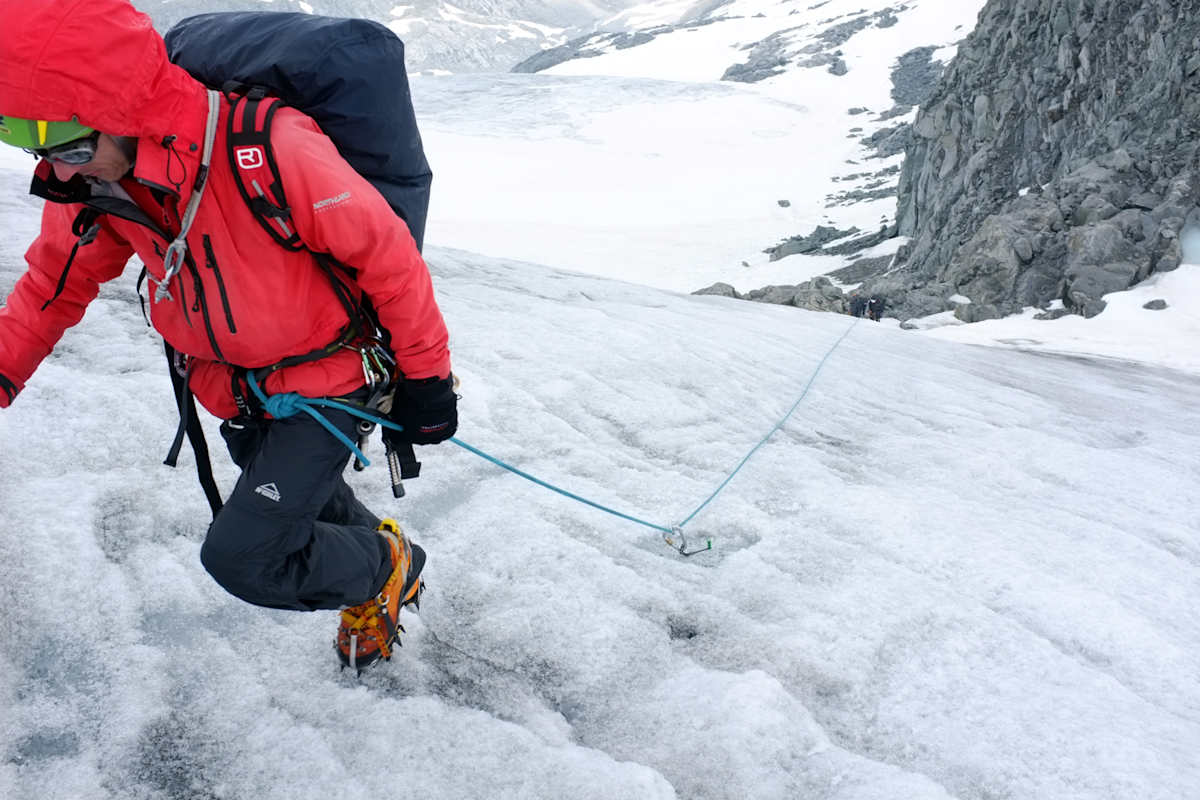 Eingehängte Fixpunkte: Wenn es steiler wird, können eingehängte Fixpunkte (hier eine Eisschraube) einen kompletten Seilschaftsabsturz verhindern. Dafür gibt es unterschiedliche Techniken, die situationsbedingt korrekt angewendet werden müssen.