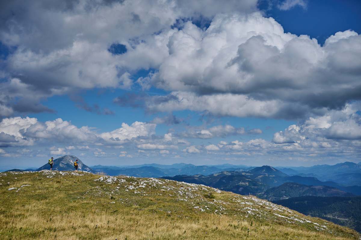 zwei Wanderer auf dem Weg zum Dürrenstein im Mostviertel, bewölkter HImmel und Berglandschaft