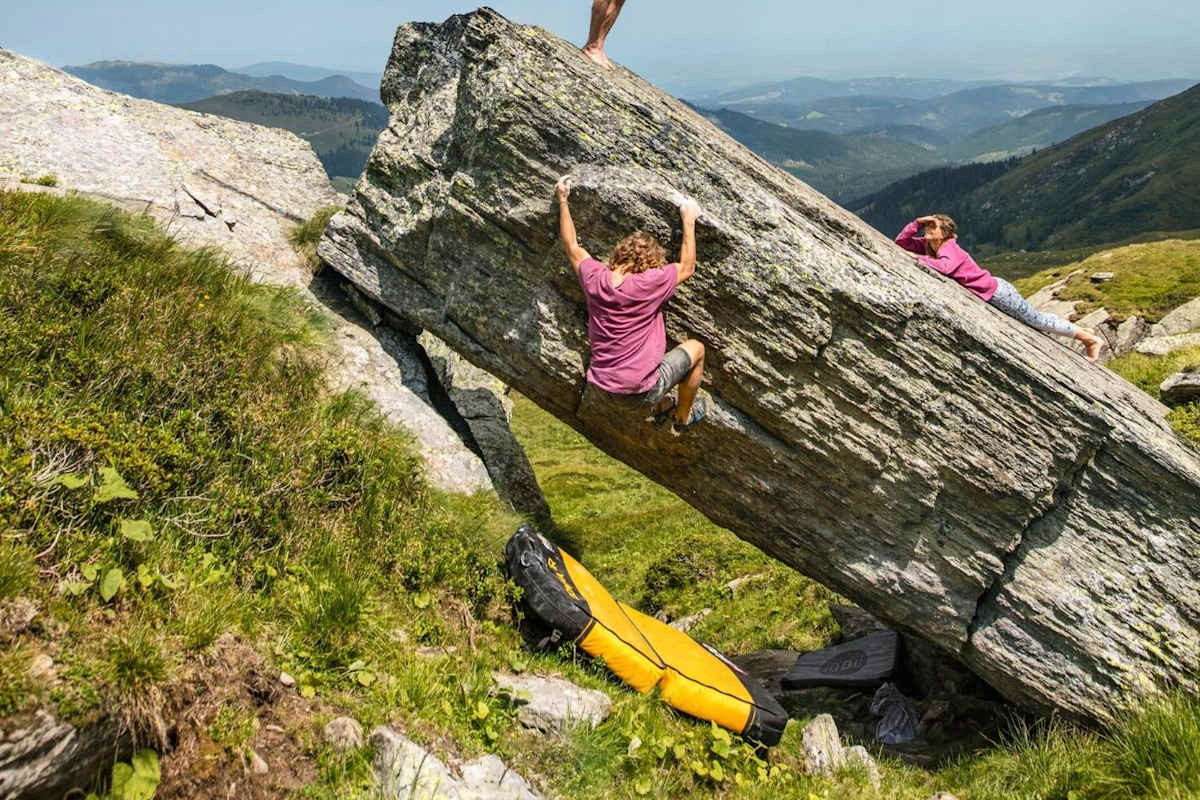 Die Damen klettern am Fels während Timo einen Drachen steigen lässt.