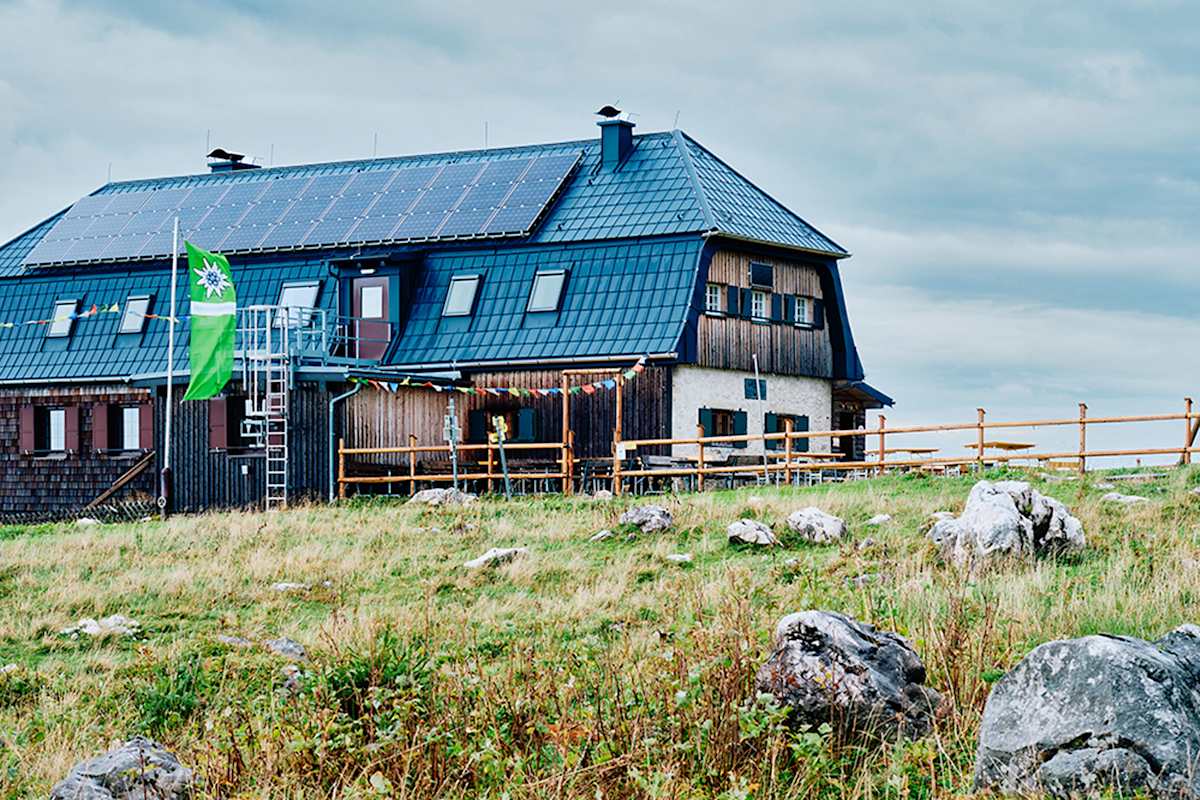 Hochleckenhaus in Oberösterreich; Berghütte mit Alpenvereinsfahne und Gebetsflagge vor dem Haus