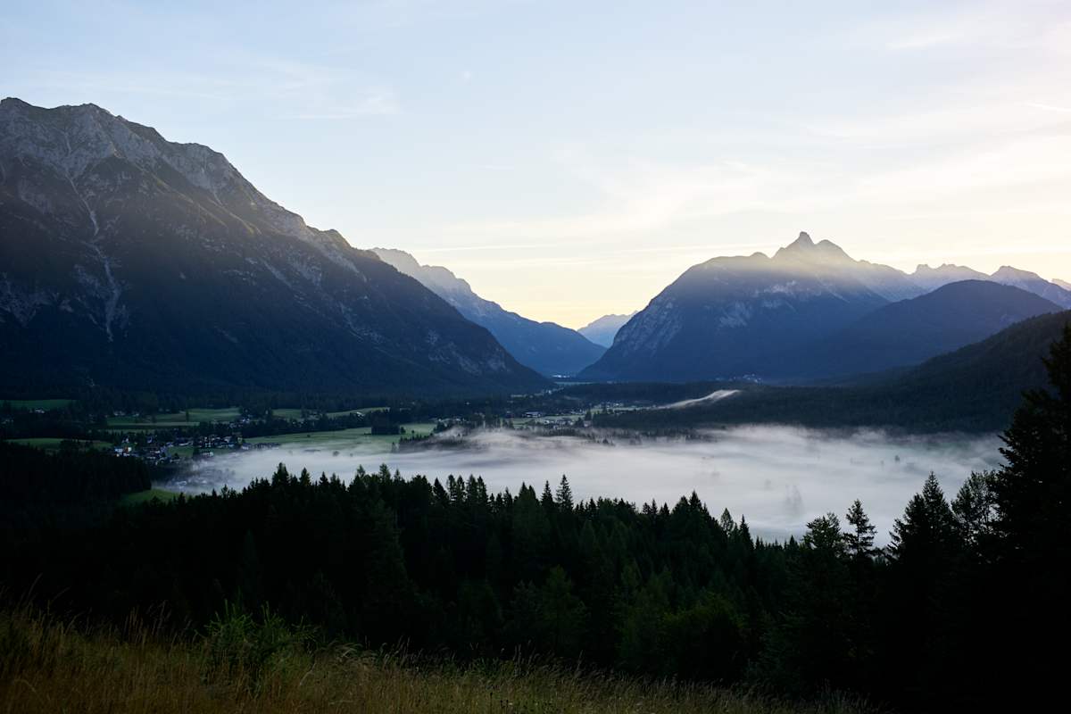 Nebel liegt unter den Bergen.