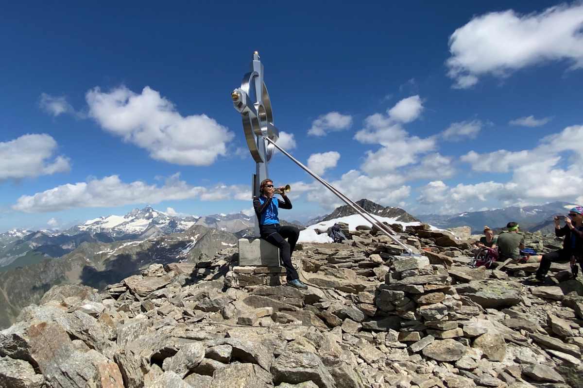 Der Musiker Martin Gratz nimmt seine Trompete regelmäßig auf Berggipfel mit – hier zum Beispiel am Glödis (3.206 m) in Osttirol.