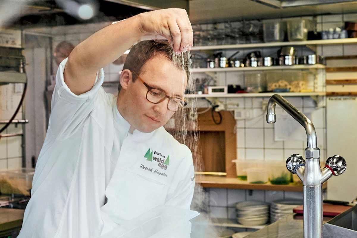 Ein Koch stellt das heiße Wasser zu.