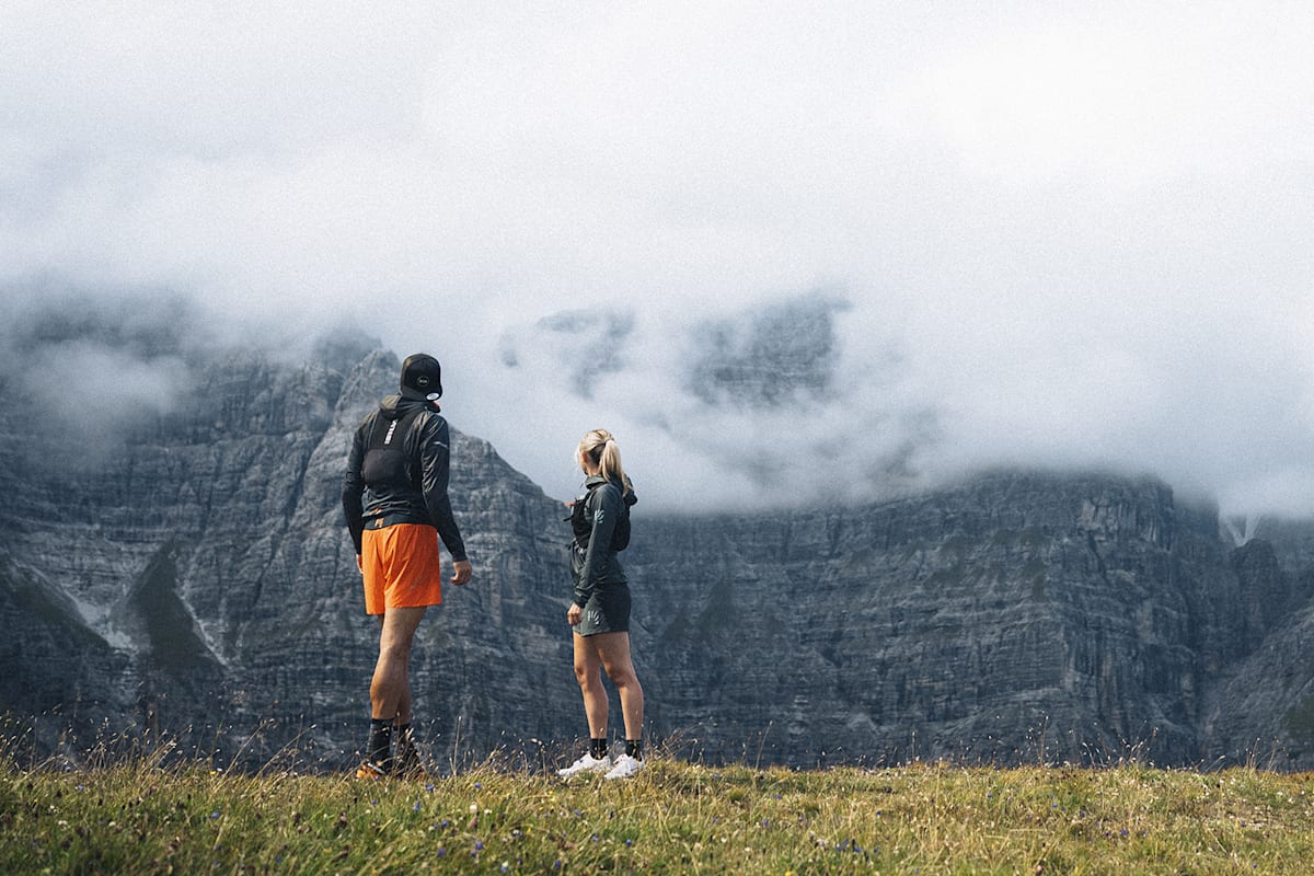 Ein Mann und eine Frau stehen am Berg und sehen sich die Umgebung an.