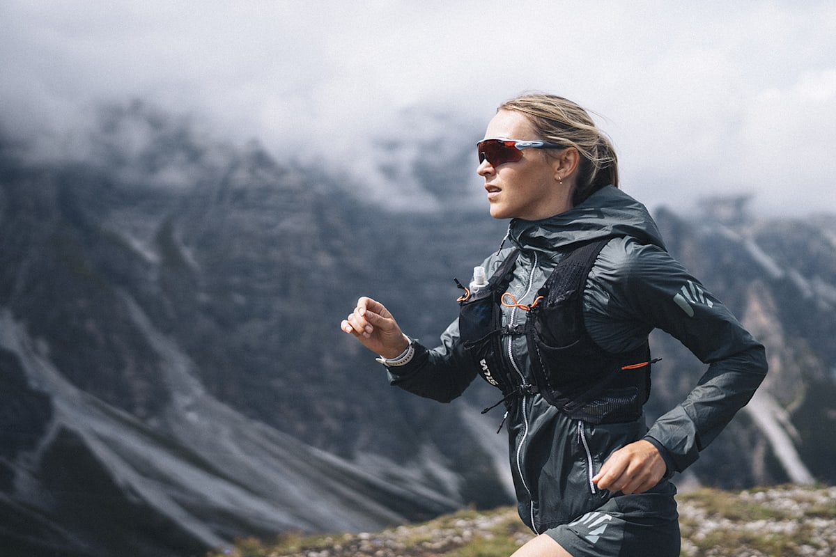 Eine Dame trägt die Lavaredo Wind Jacket von Karpos auf dem Trail