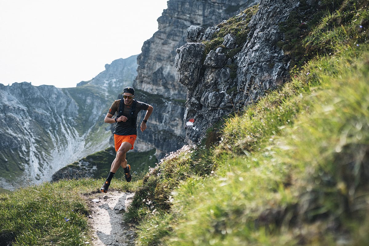 Ein Mann läuft auf dem Trail im Gebirge.