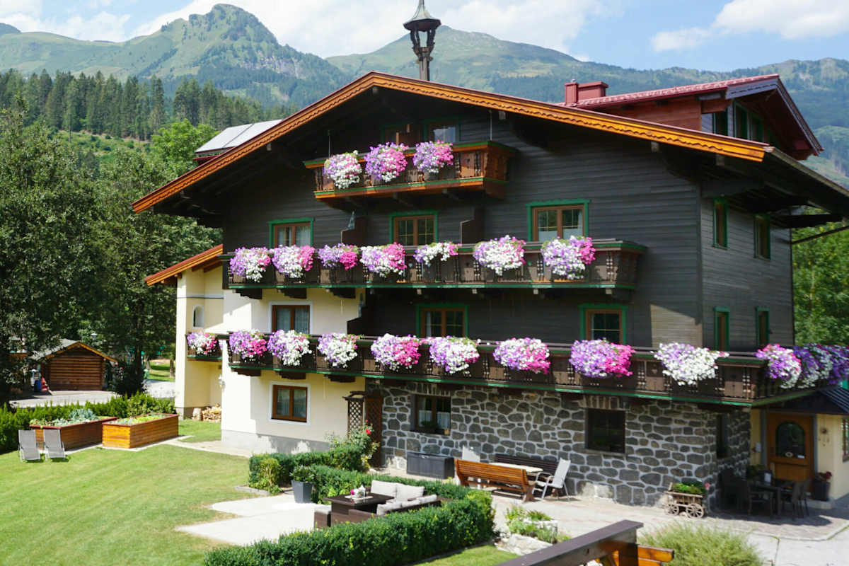 Bio Bauernhof Kendlgut in Badhofgastein umringt von Bäumen und Bergen im Hintergrund