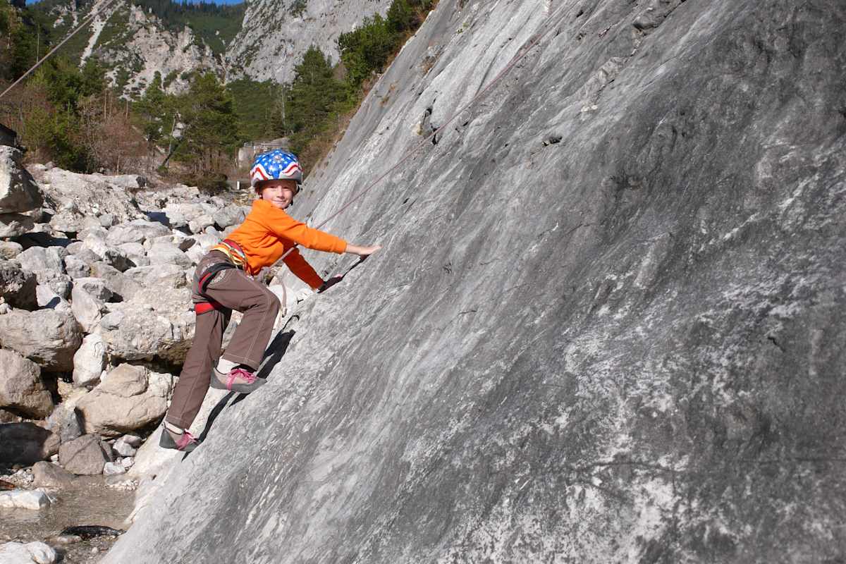 Kind beim Klettern am Fels