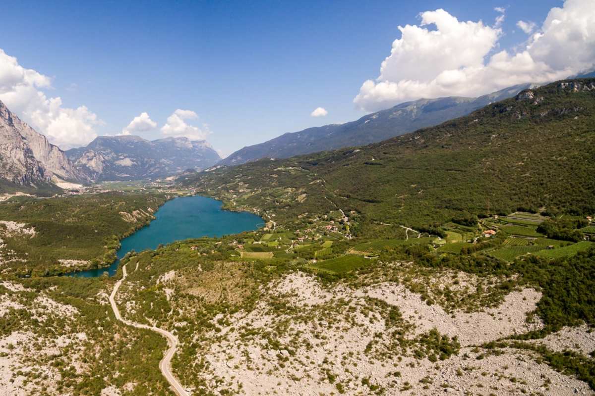 Strahlend blau hebt sich der Lago di Cavedine von der kargen Mondlandschaft der Marocche ab.