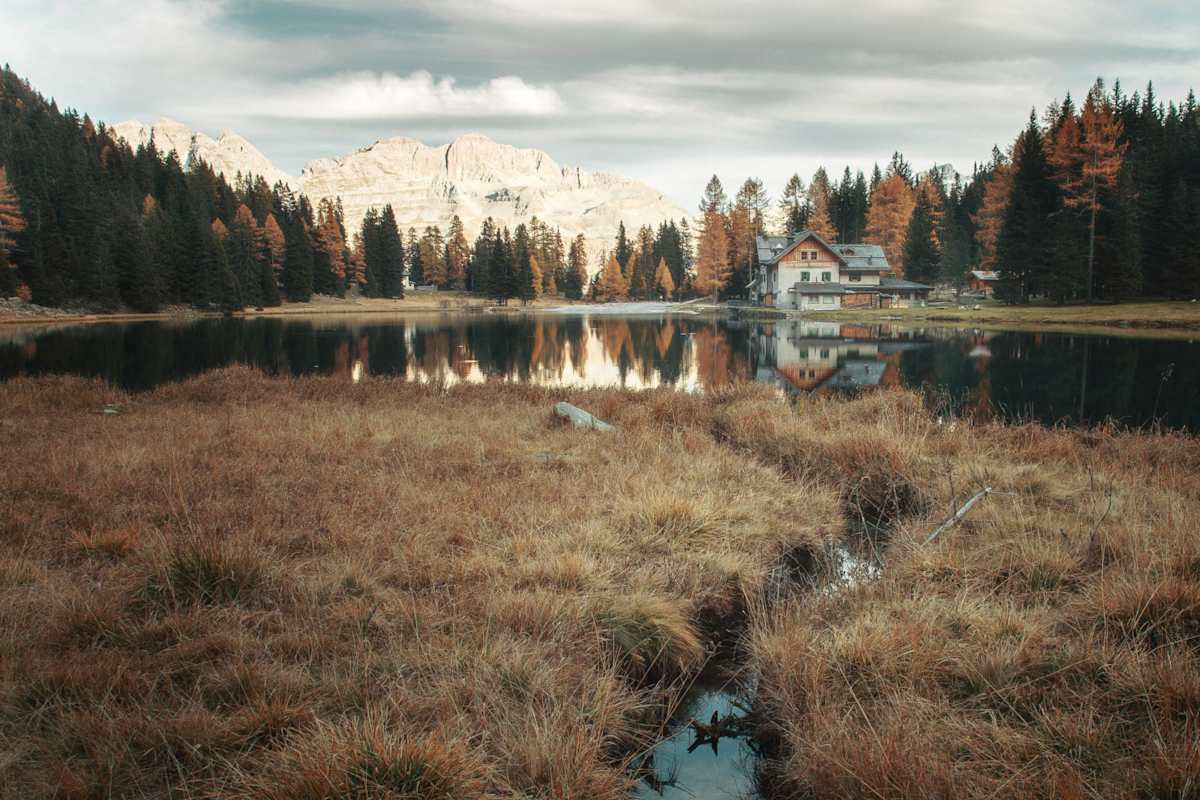 Eingebettet zwischen dunklen Tannenwäldern liegt der Lago di Nembino malerisch vor der Kulisse der Brenta-Dolomiten.