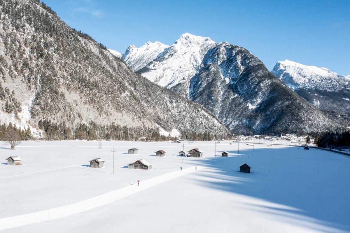 In Scharnitz läuft man über flache Wiesen vorbei an den zahlreichen Heustadeln.