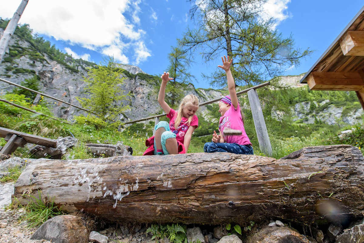 Zwei Mädchen spielen an einer Quelle.