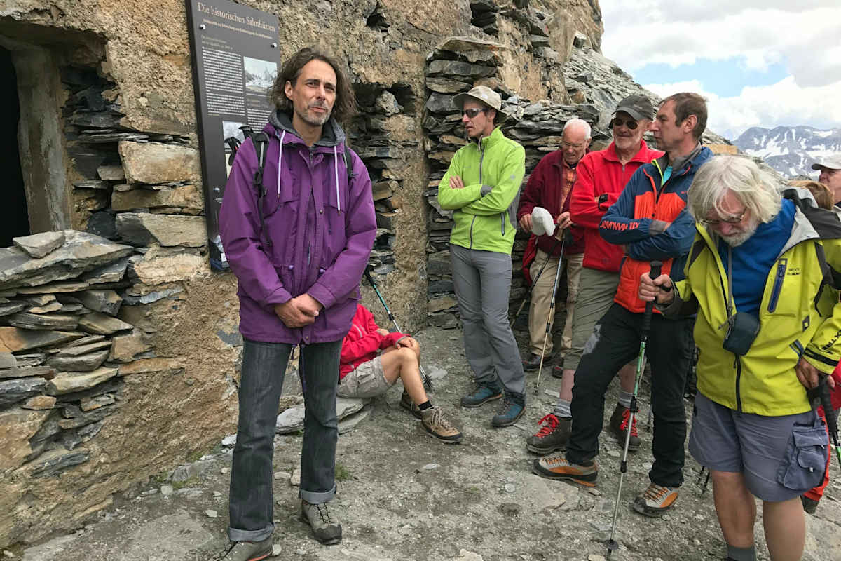 Michael Guggenberger, Archivar des Österreichischen Alpenvereins, erläutert die Geschichte der Salmhütte vor der alten Hütten, die in den Felsen des Schwertecks gesprengt wurde.