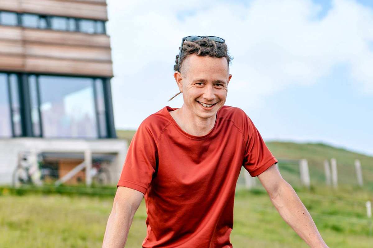 Der Architekt mit seinem Bike vor der Hütte.