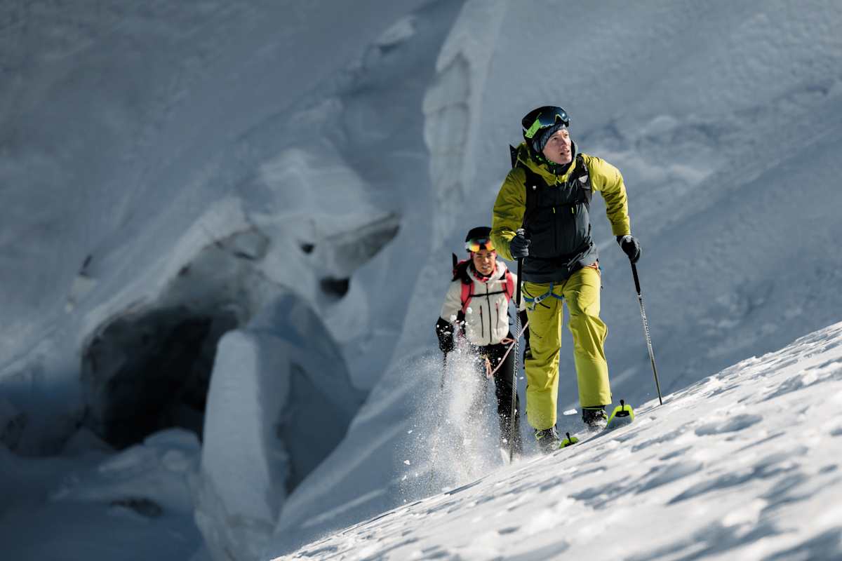 Skitourengeher mit Dynafit Blacklight-Ausrüstung beim Aufstieg durch tiefen Schnee im Gebirge.