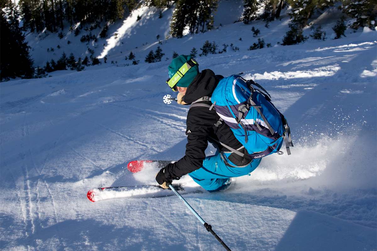Ein Skifahrer zieht Schwünge auf einer steilen Piste.