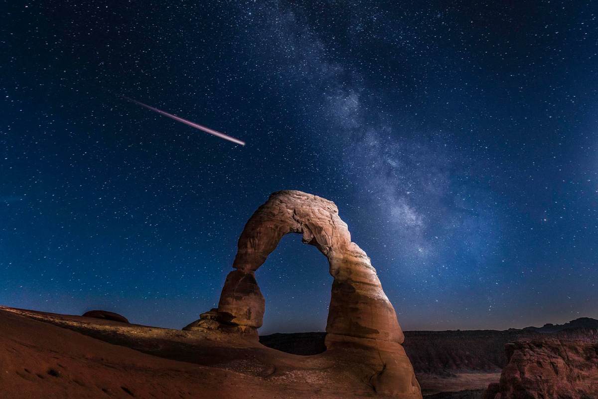 Der Felsbogen Delicate Arch mit der Milchstraße und einer Sternschnuppe im Hintergrund, Arches Nationalpark in Utha, Nordamerika