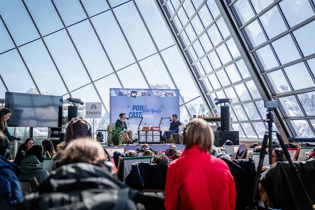 Podcast-Festival: Simon Messner und Klaus Haselböck auf der Bühne mit Publikum vor Bergkulisse