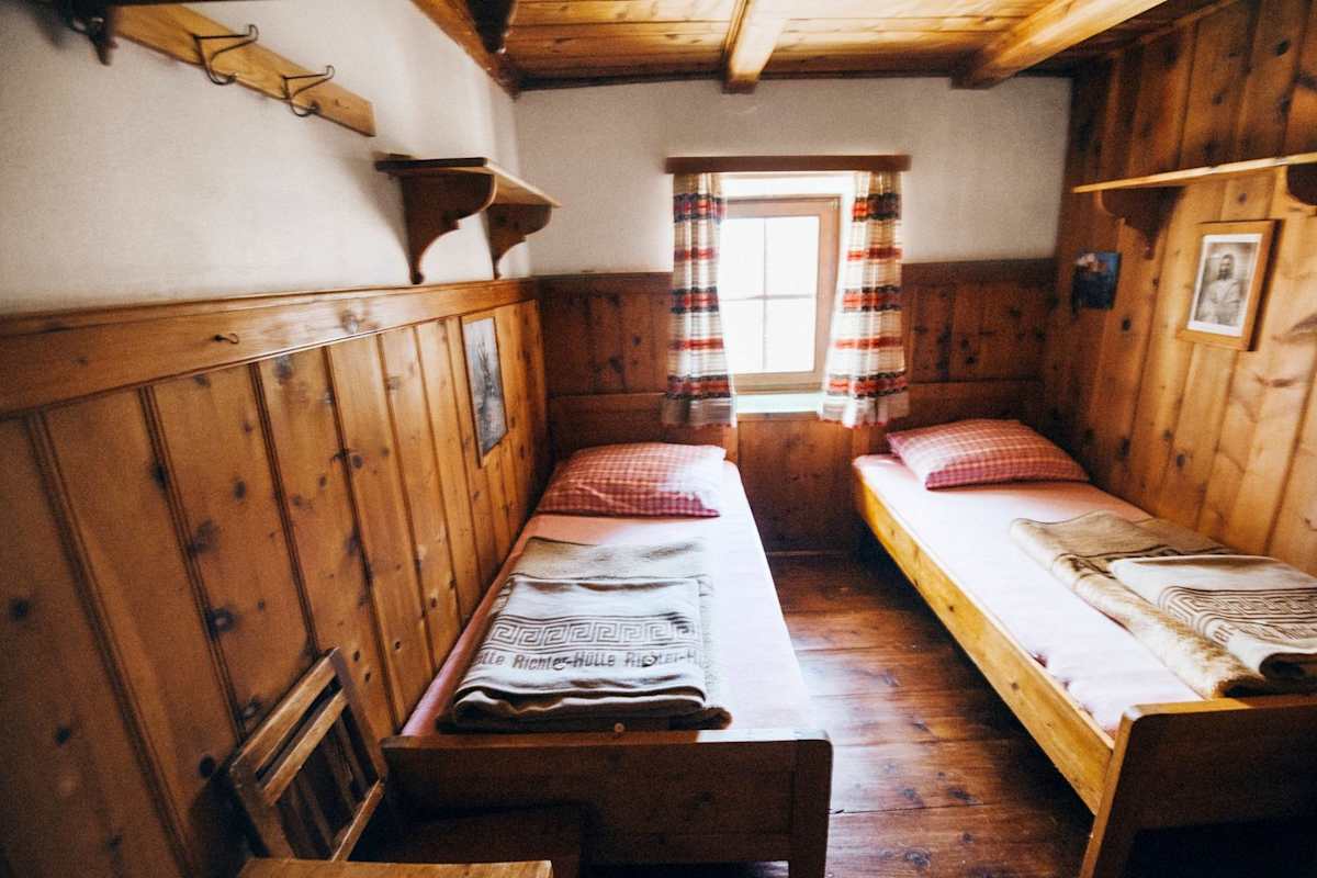 Die urigen Zimmer aus Zirbenholzmöbel mit klassisch rotkarierter Bettwäsche