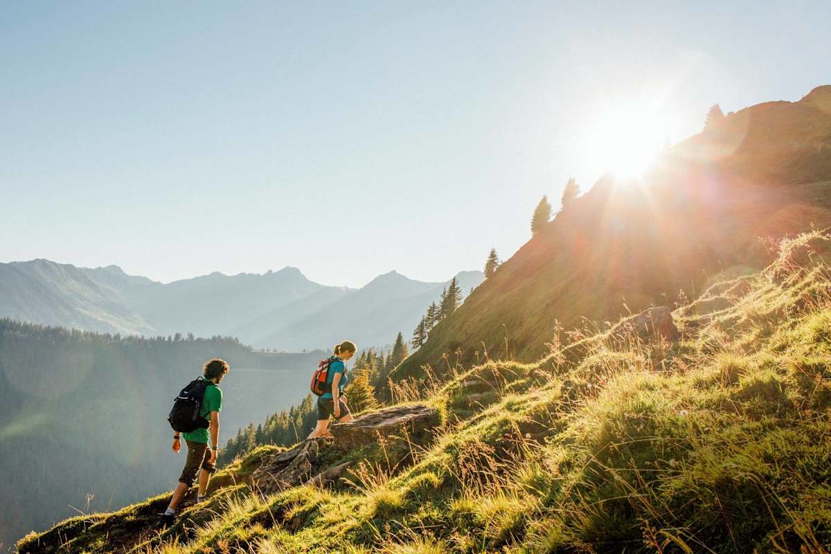 Das Sonnenlicht streift die Grasberge des Glemmtals