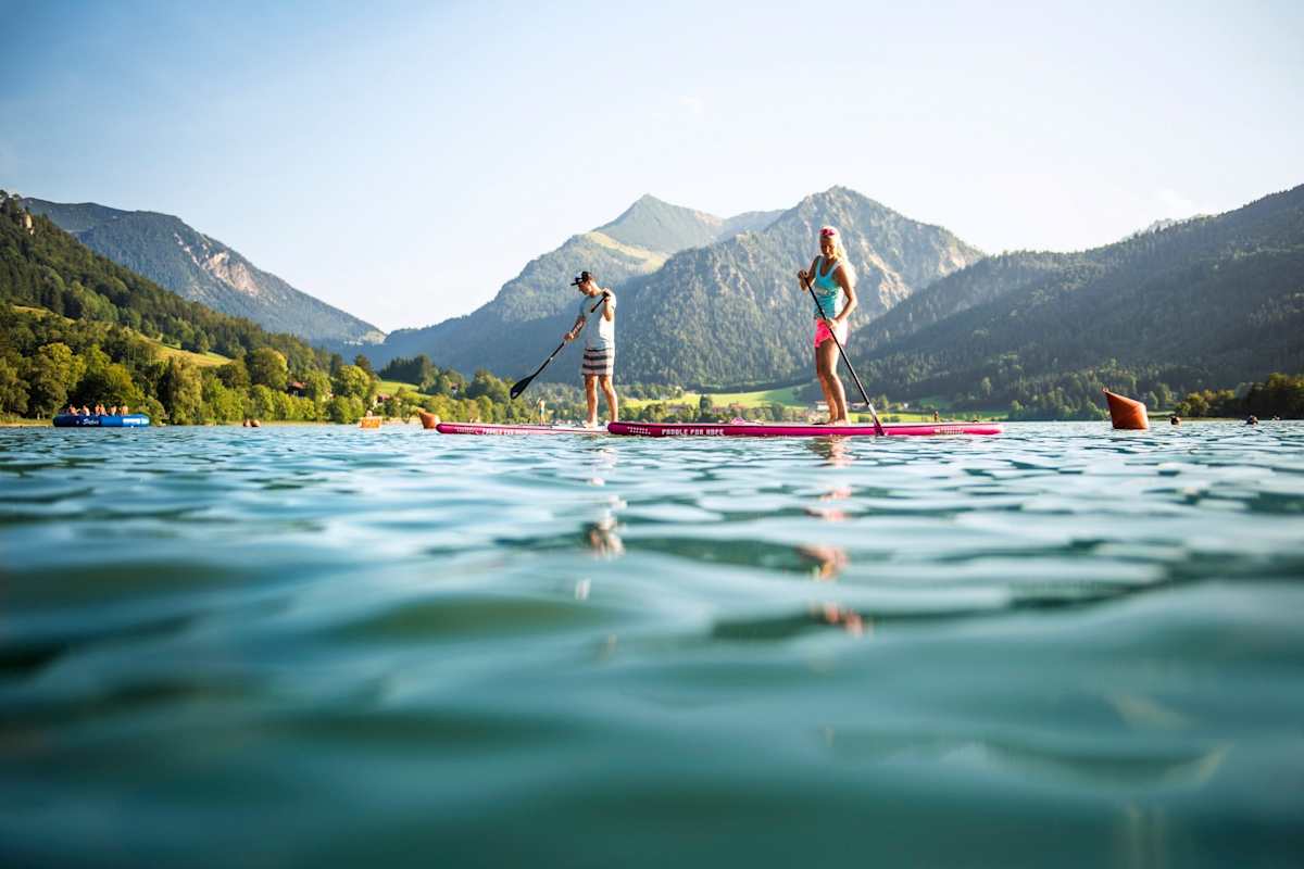 Zwei Sportler sind am See aktiv. 