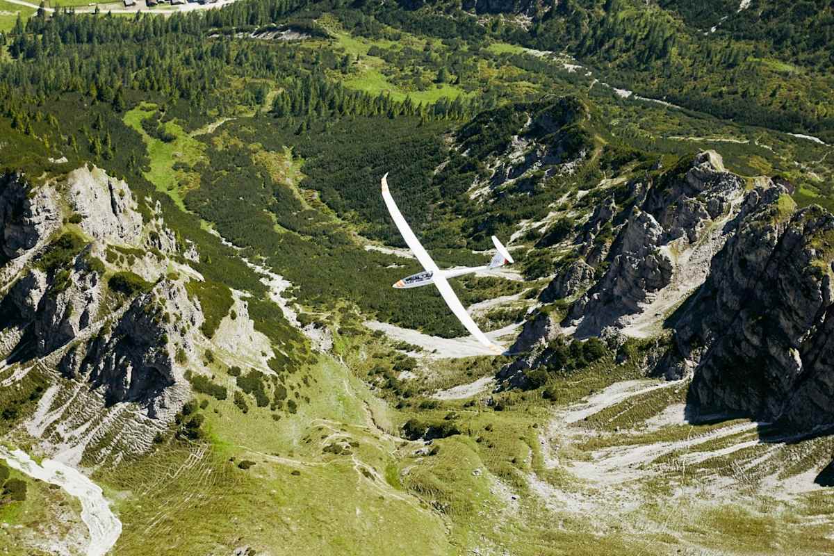 Das Flugzeug ist kaum zu erkennen in den Bergen.