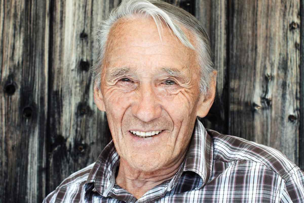 Der Hüttenwirt vor seiner Berghütte.