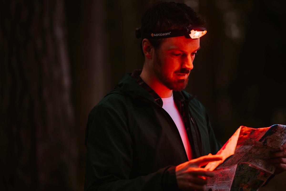 Wanderer beim Lesen einer Karte mit dem Rotlichtmodus der Suprabeam V7