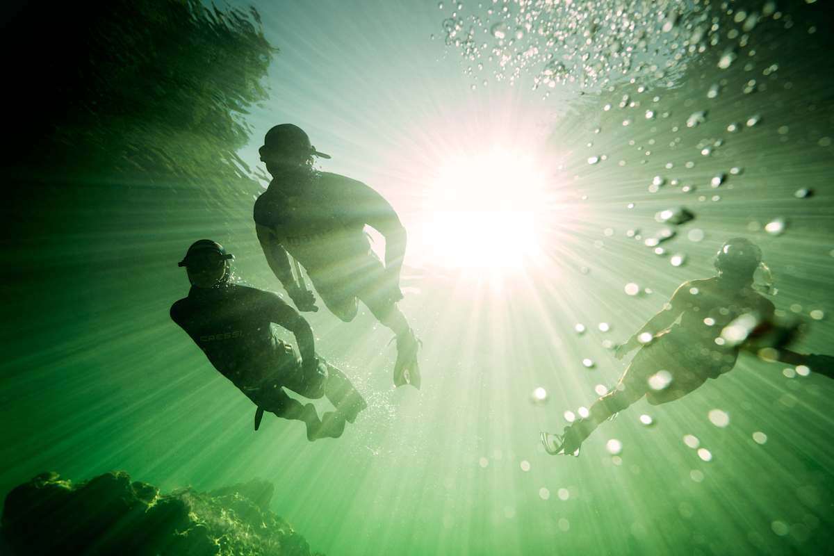 Drei Schnorchler in der Tiefe.