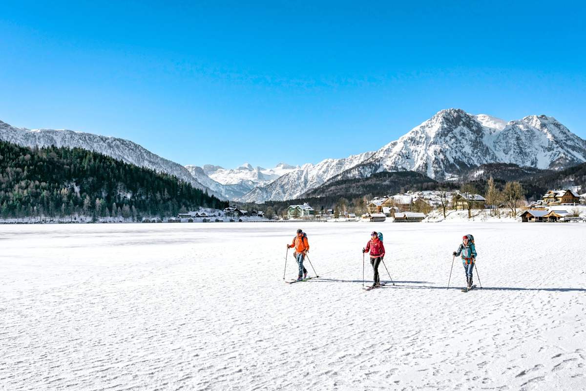 Bergsteiger spazieren am See entlang.
