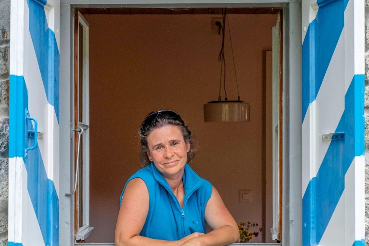 Die Hüttenwartin Franziska lacht aus dem Fenster.
