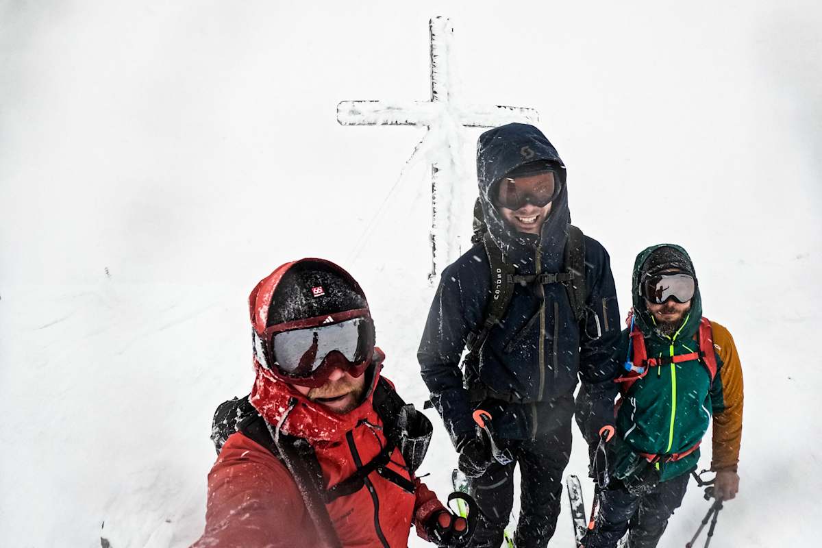 Skitourengeher beim Gipfelkreuz am Hohen Zinken