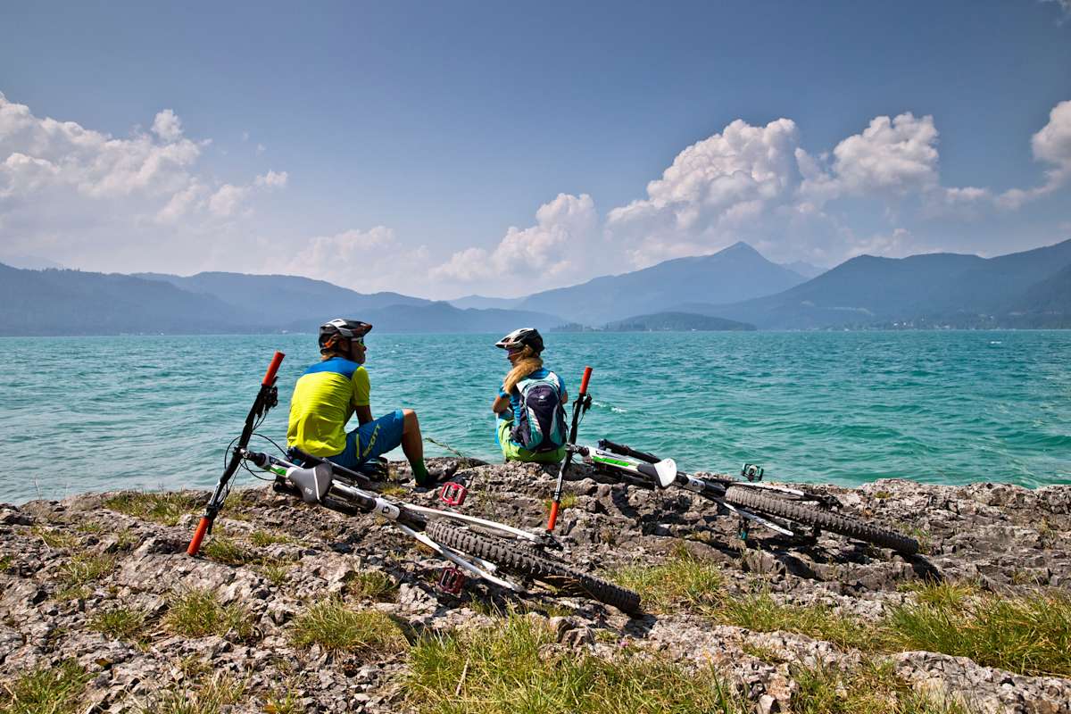 Zwei Radfahrer machen eine kurze Rast am Ufer.