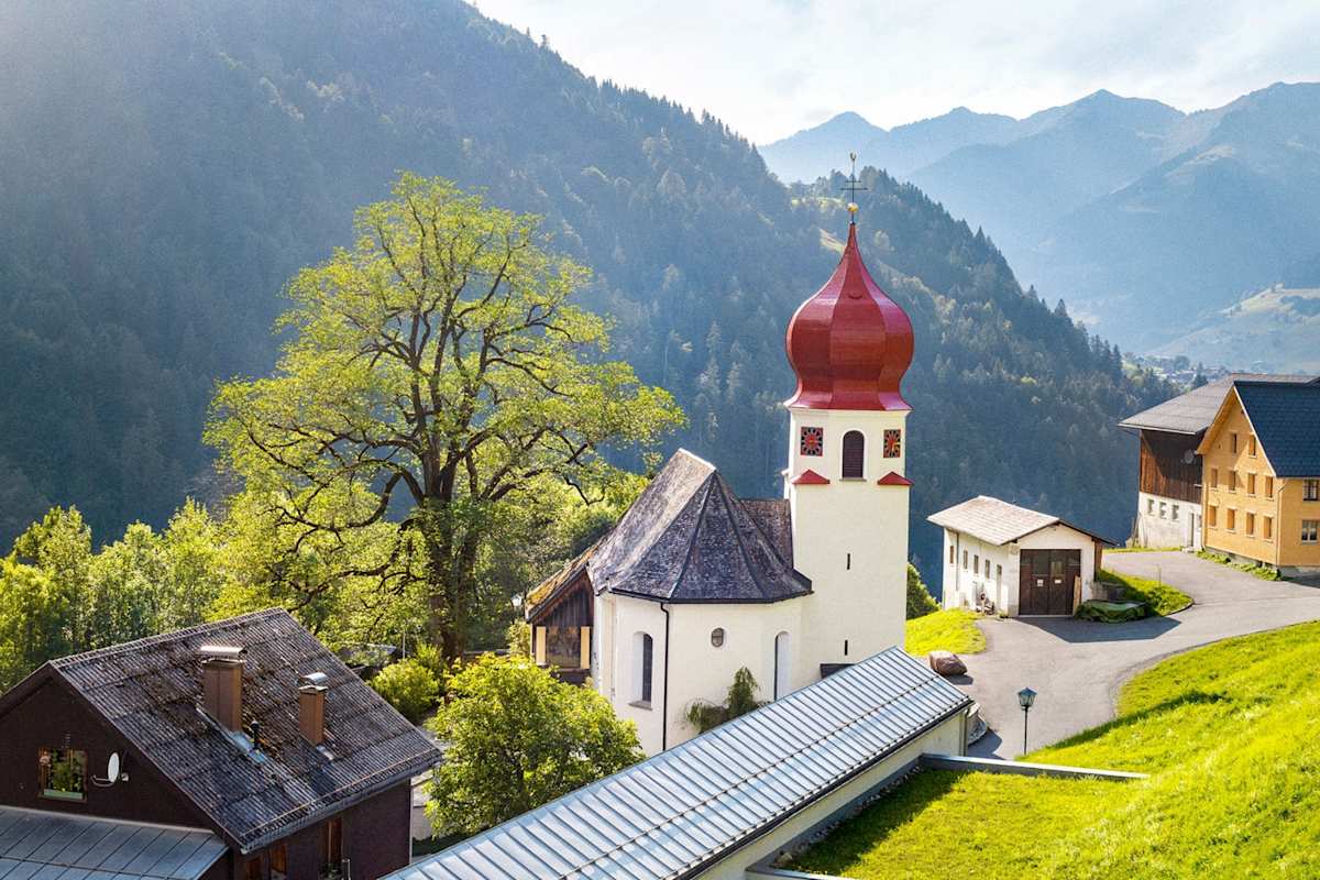 Eine Kirche verzaubert die Berglandschaft.