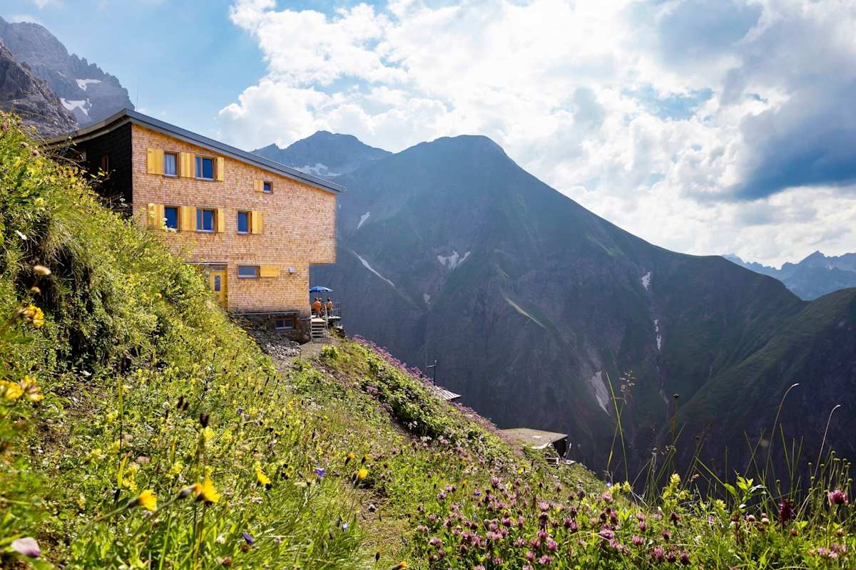 Die Hütte schmiegt sich an den Grashang und bettet sich in die Landschaft ein