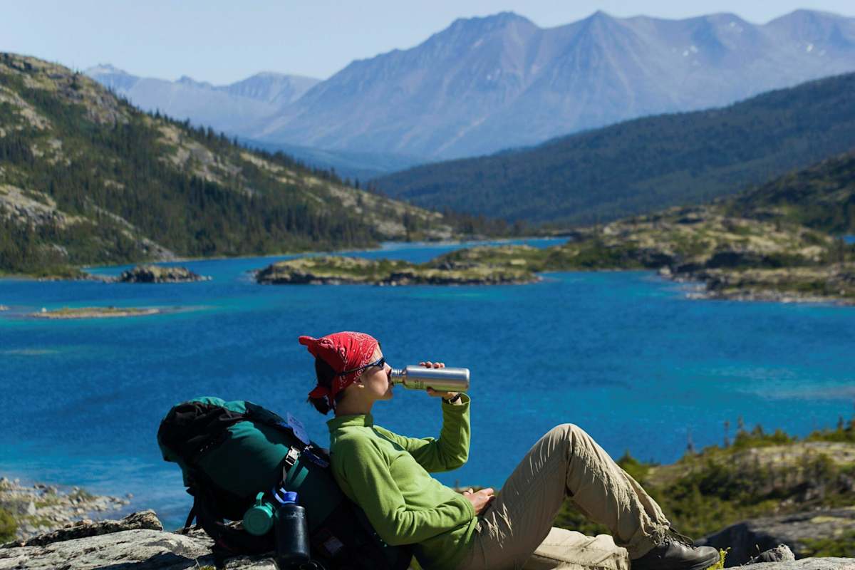 Trinkpause: Wanderin an einem Bergsee in Kanada