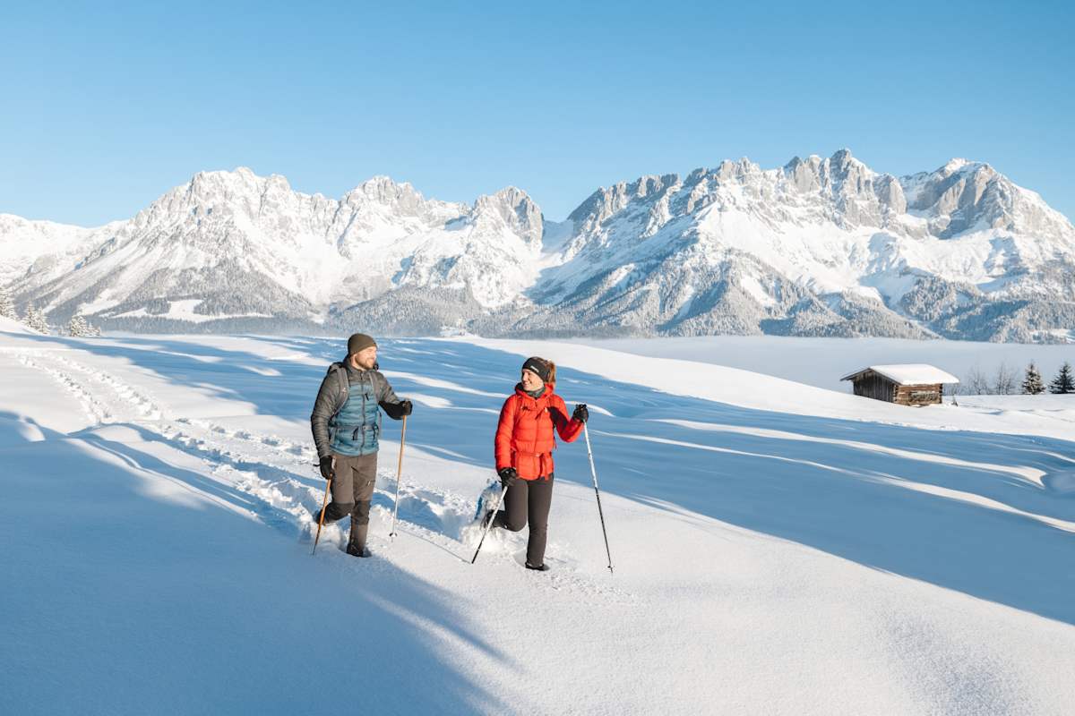 Ein Pärchen wandert mit Schneeschuhen durch die tief verschneite Bergwelt des Wilden Kaisers.