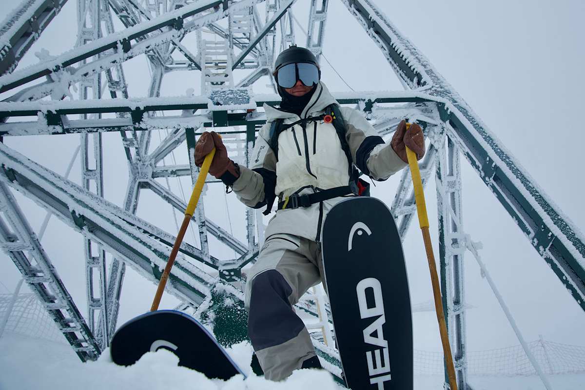 Freerider Tao Kreibich steht mit HEAD-Ski vor einer vereisten Metallkonstruktion in winterlicher Umgebung.
