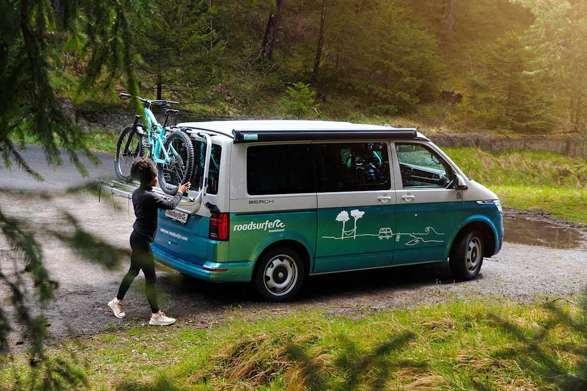 Mit dem Bike am Camper und dem Wald vor der Tür.