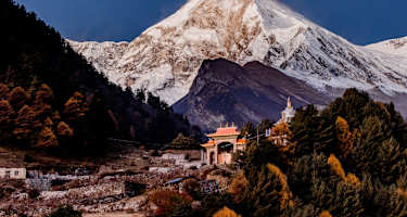 Ein Kloster und dahinter der mächtige Manaslu im Licht des Morgens