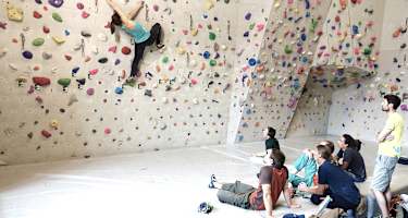 Eine Sportkletterlehrerin ist für Ausbildung und Training beim Bouldern und Vorstiegsklettern qualifiziert. 