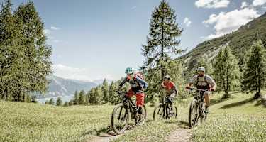 Mountainbiker am Trail in grüner Landschaft in Nauders Südritol